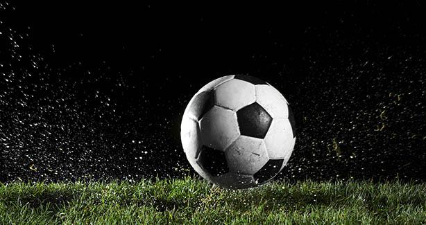 Illuminated soccer ball on a green field